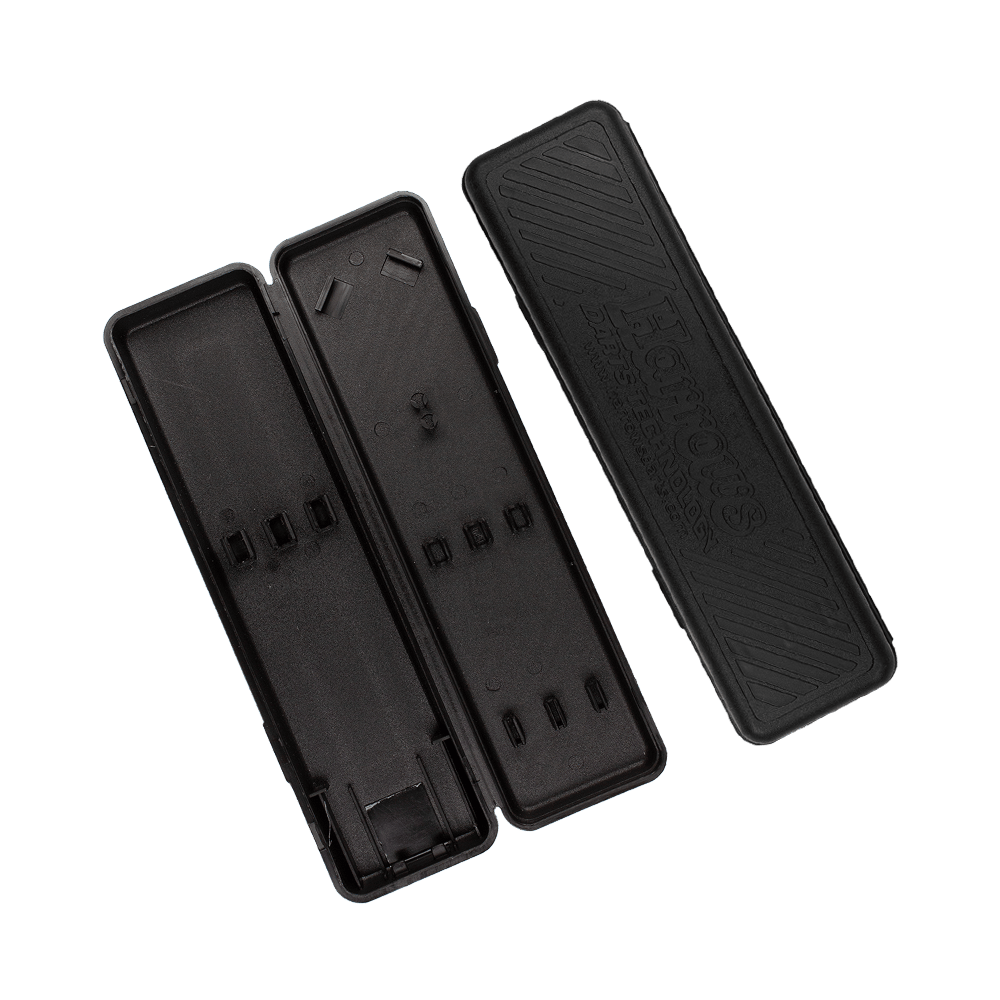Plastikbox-Harrows6zrmsWC1nCUzw Das Bild zeigt ein leeres, geöffnetes schwarzes Darts-Etui der Marke Harrows. Der Deckel mit der Aufschrift „Harrows“ liegt neben dem Etui.