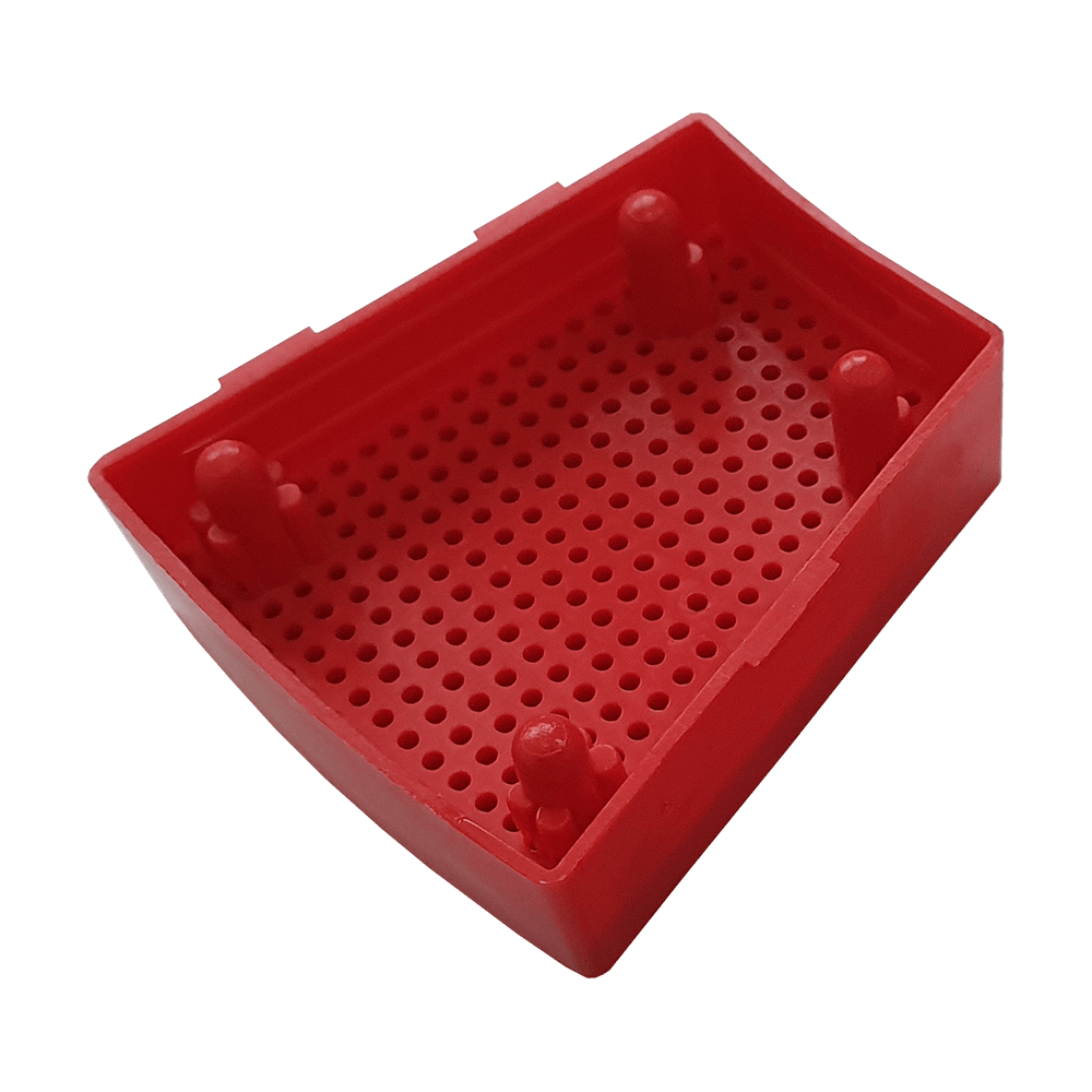 GRN0151_Granboard_132_Ersatzfelder_Single_Aussen_Rot_3 Das Bild zeigt ein rotes Ersatzfeld für das Granboard 132. Das Kunststoffteil hat eine rechteckige Form mit vielen kleinen Löchern und vier Erhebungen.