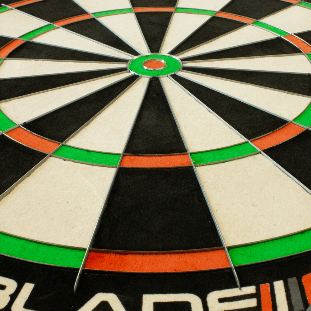 3032_Winmau_Blade_6_TripleCore_Steeldartboard_4 Das Bild zeigt eine Nahaufnahme des Winmau Blade 6 TripleCore Steeldartboards. Deutlich zu sehen sind die farbigen Segmente sowie das Bullseye in der Mitte.