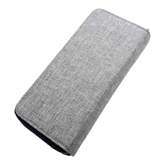 Das Bild zeigt ein graues, rechteckiges Etui mit Stoffüberzug. Das Etui liegt auf einem schwarzen Hintergrund.