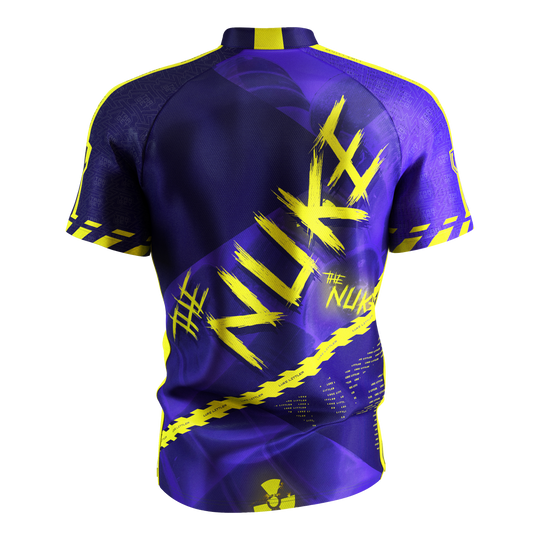 Target Coolplay Luke Littler 2025 dart shirt Das Bild zeigt das „Target Coolplay Luke Littler 2025 Dartshirt“ von hinten. Das Shirt ist überwiegend lila mit auffälligen gelben Designs und dem Schriftzug „NUKE“ auf dem Rücken.