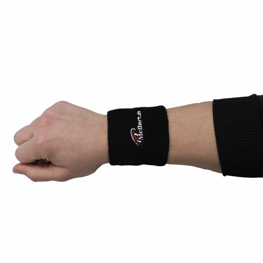 1690 Auf dem Bild ist ein schwarzes Schweißband mit der Aufschrift "McDart" zu sehen. Es wird am Handgelenk einer Person getragen.