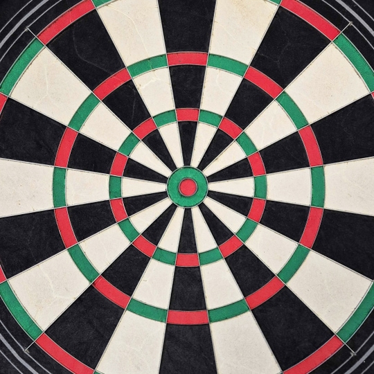 Harrows Quadro 240 steel dartboard Das Bild zeigt eine Nahaufnahme des Harrows Quadro 240 Steeldartboards. Das Dartboard ist in verschiedene Abschnitte in den Farben Schwarz, Weiß, Rot und Grün unterteilt.