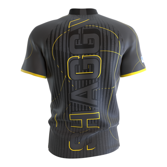 Das Bild zeigt das Target Coolplay Collarless Scott Williams Dartshirt von hinten. Das Shirt ist grau mit gelben Akzenten und dem großen Schriftzug "SHAGGY" auf dem Rücken.